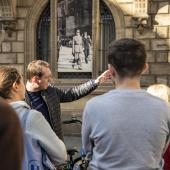 Photographie d'une visite commentée devant la façade du Centre national Jean Moulin