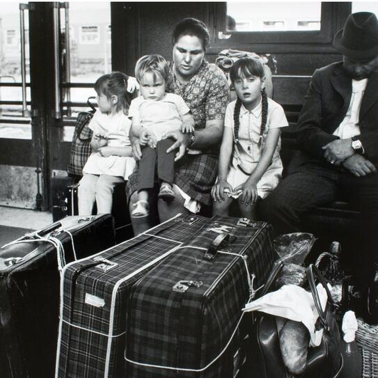 IMage d'une famille attendant avec ses valises à la gare