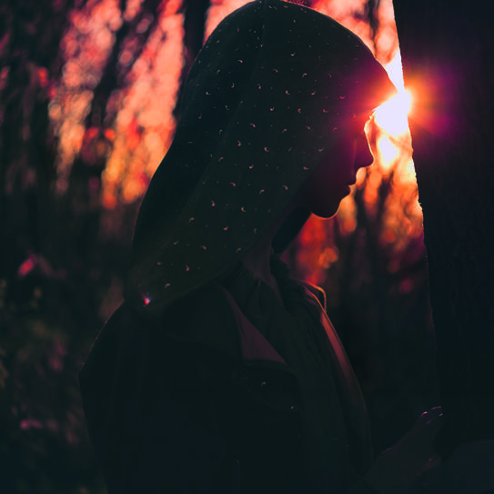 Photo d'une femme à contre jour dans la forêt