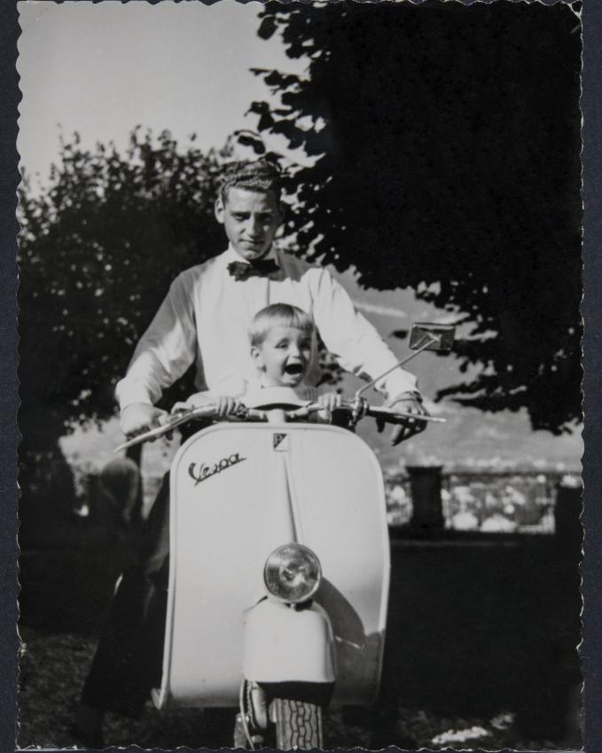Photographie d'un homme et d'un enfant en Vespa