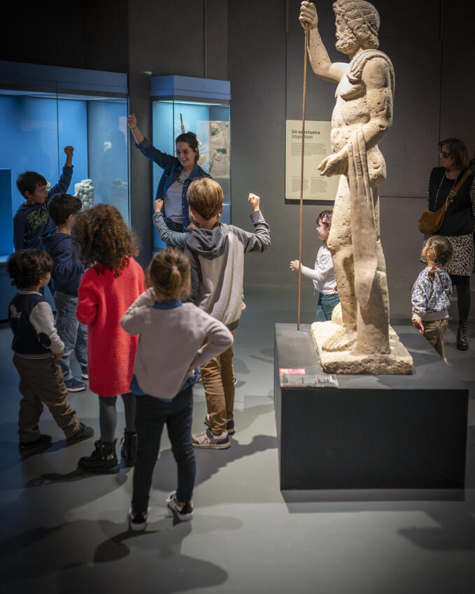 photo d'enfants essayent de faire la même position que la statut de Jupiter 