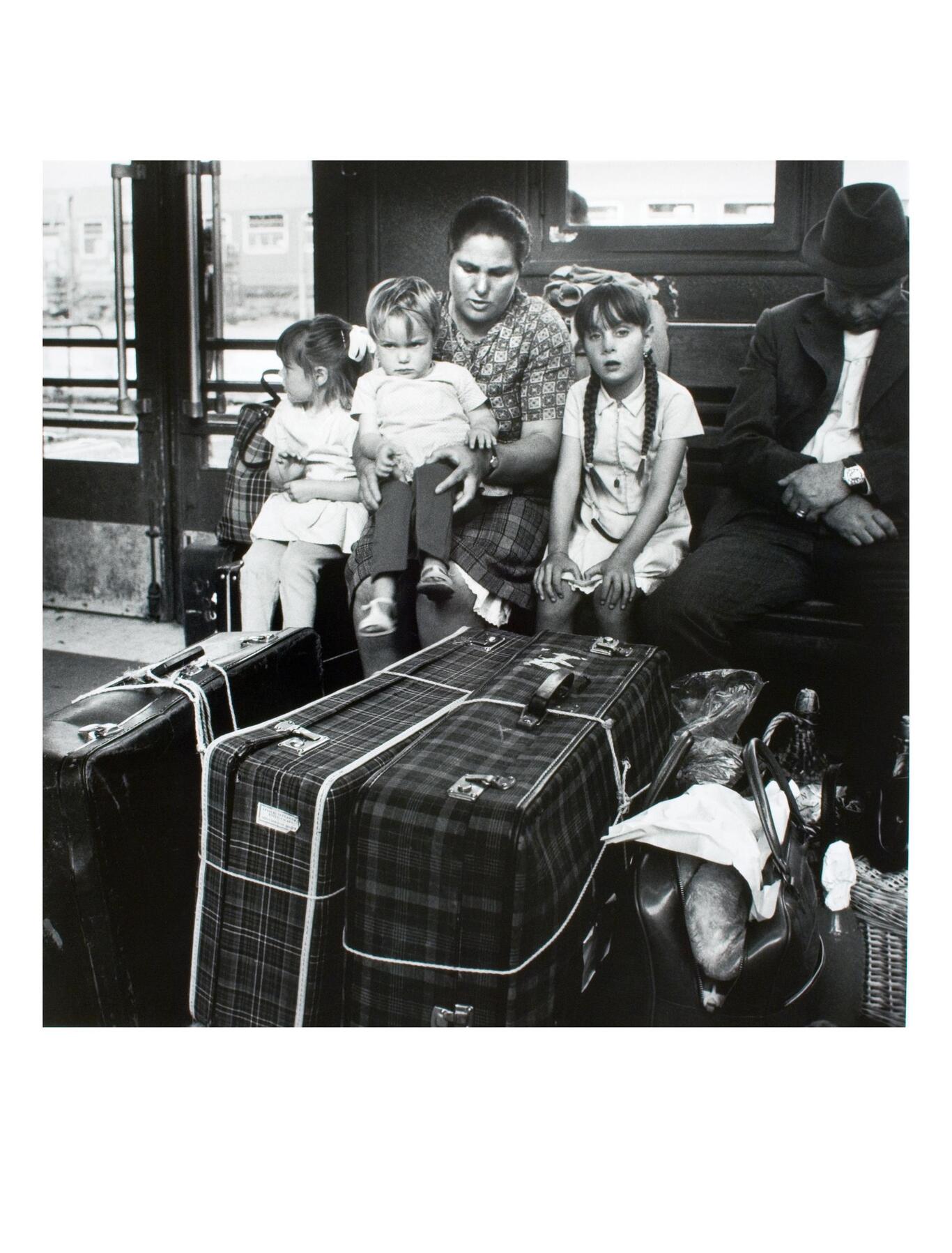 IMage d'une famille attendant avec ses valises à la gare