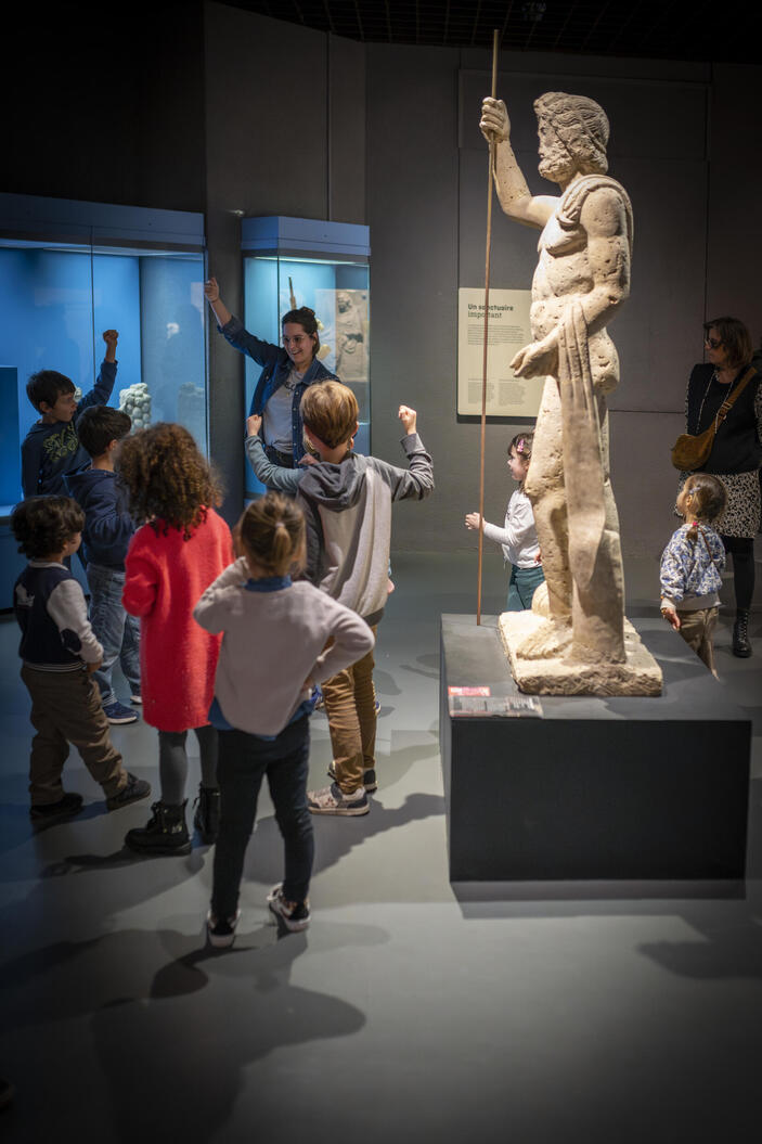 photo d'enfants essayent de faire la même position que la statut de Jupiter 