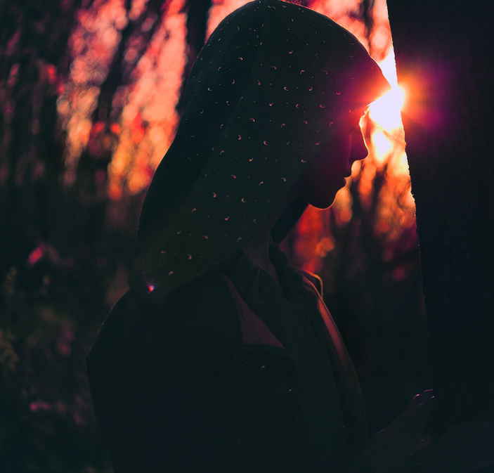 Photo d'une femme à contre jour dans la forêt